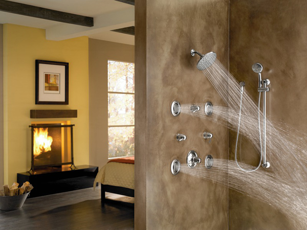 luxury shower with many showerheads and fire place in next room