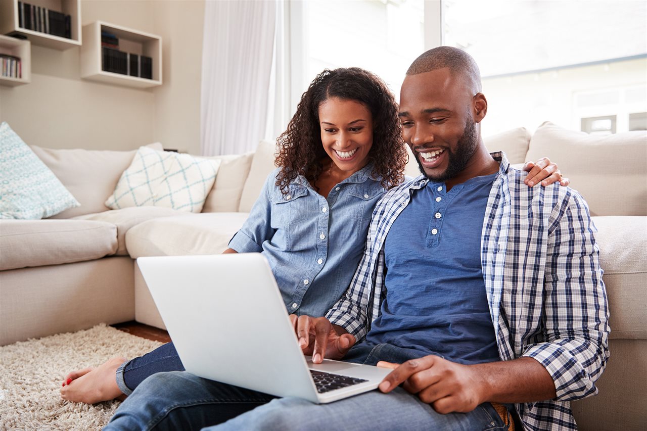 Pareja busca casas online desde su sala de estar