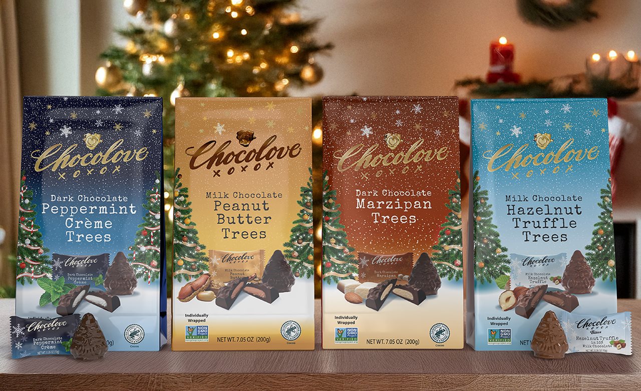 A four Chocolove chocolates bags, in a varity of flavors on a table infront of a room decorated for the holidays.