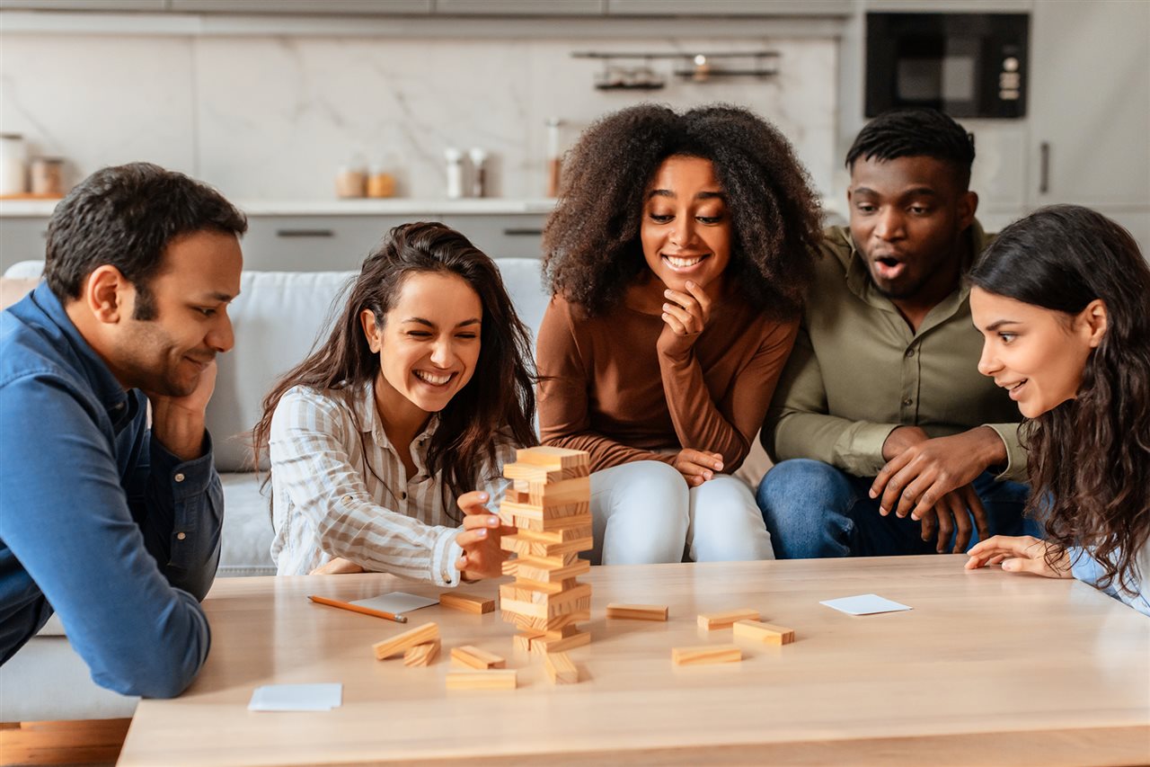 Group of friends playing a stacking game.