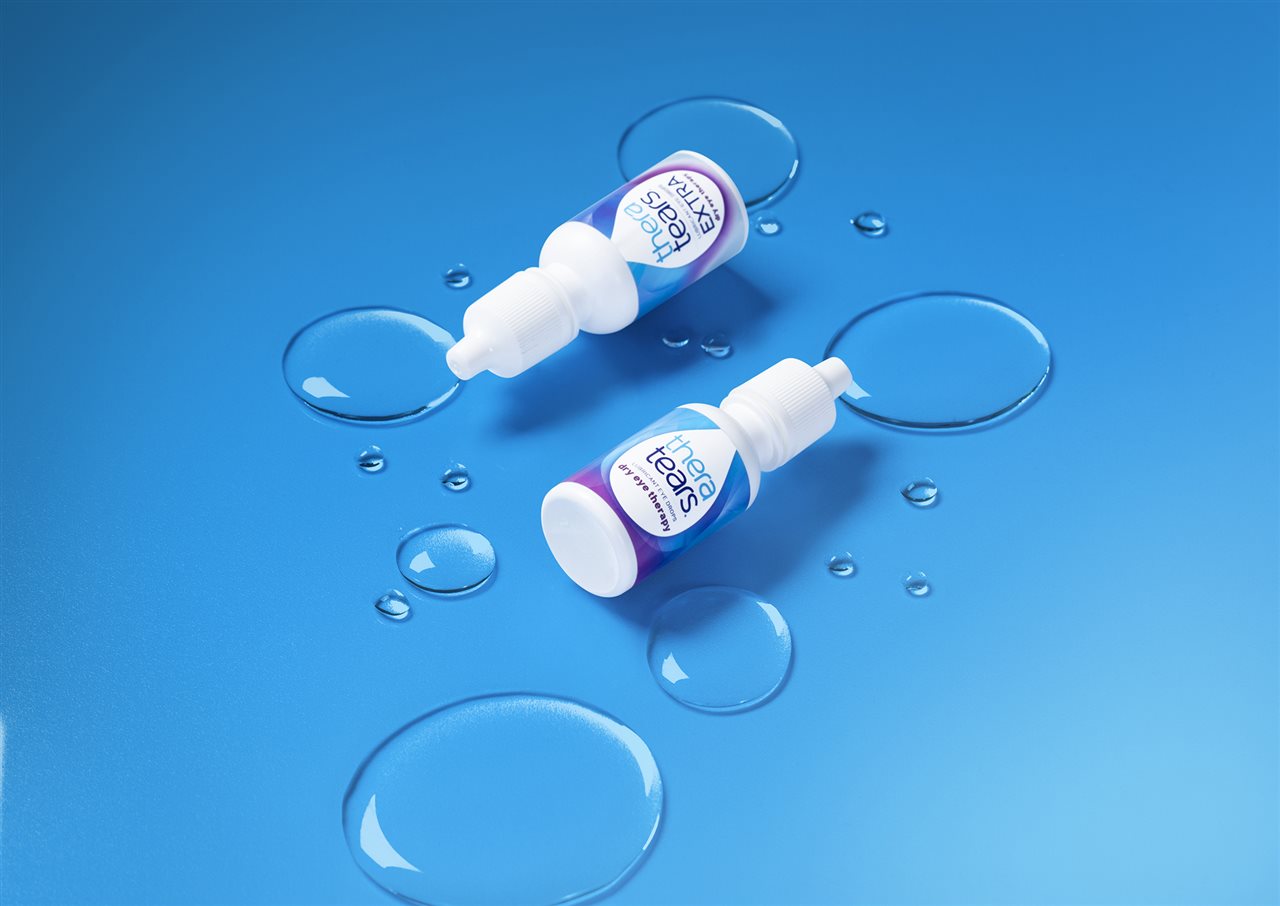 Two bottles of TheraTears eye drops on a blue background.