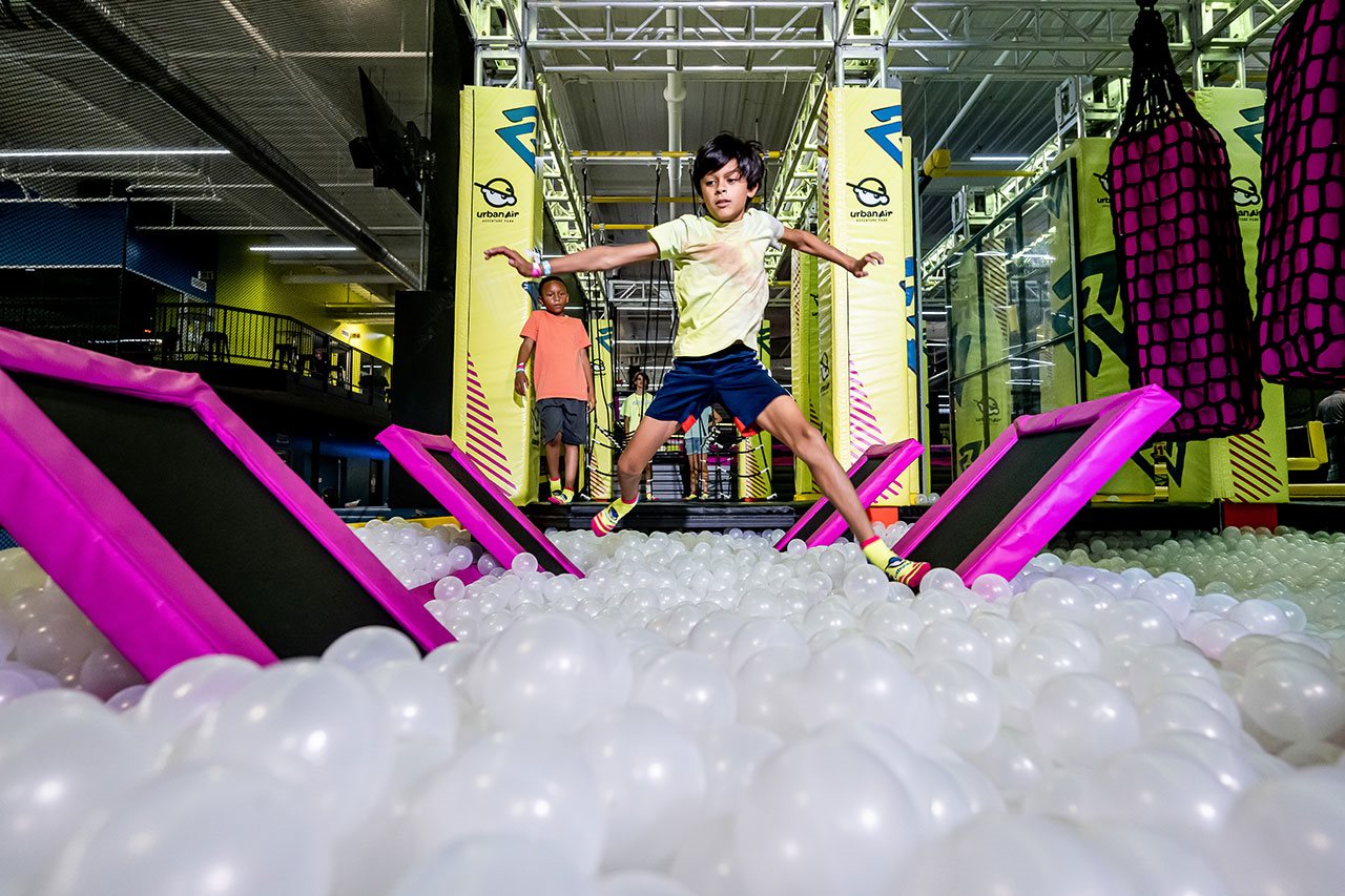 Boy playing in ball pool at Urban Air