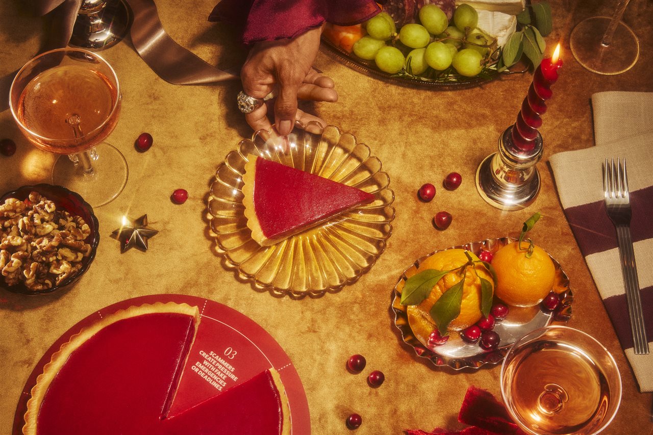 Person reaching for a plate on a table with a slice of red pie next to a pie plate with one sliced removed to reveal a message that says 