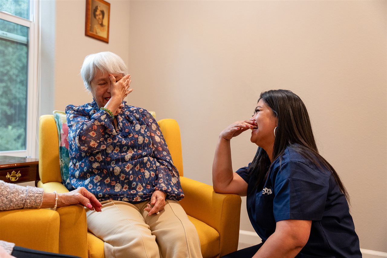 Strela's mother and caregiver from Vivid Life Home Care laughing together.