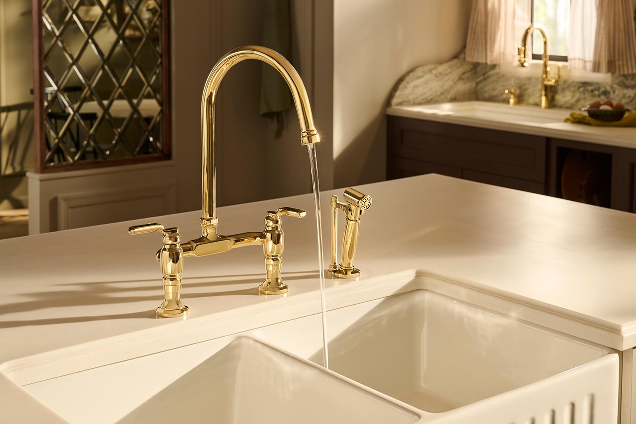 Brizo Unlacquered Brass faucet running water into a white sink.