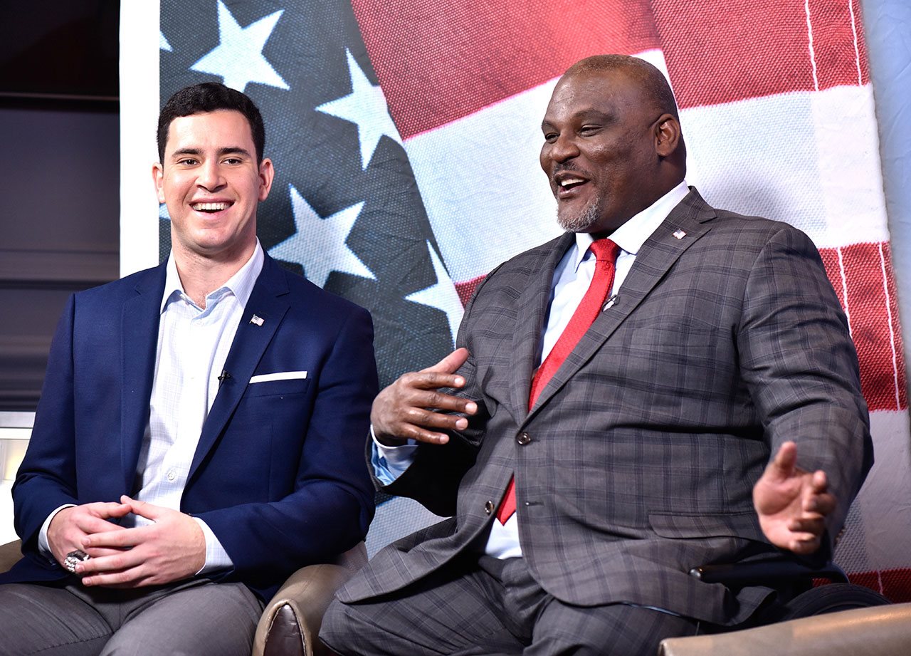 Veterans talking while seated on a stage.