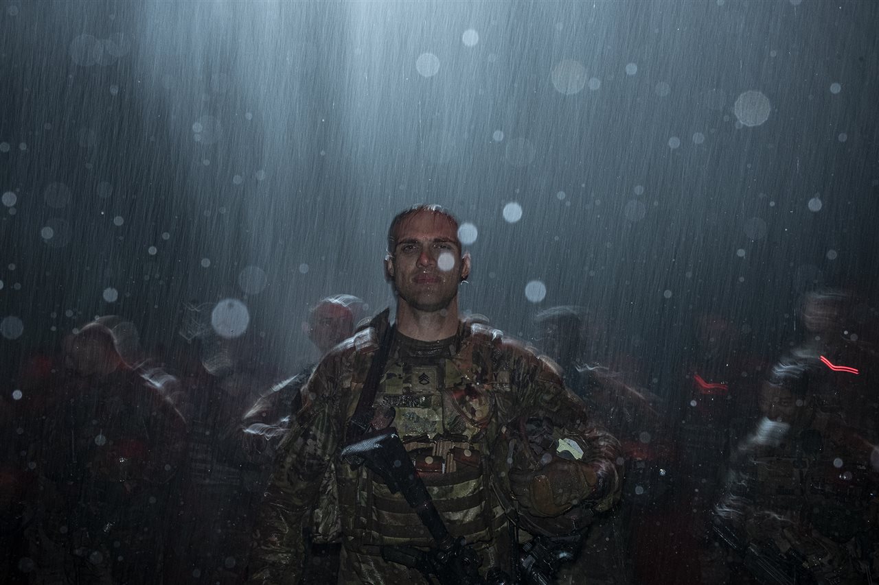 Electromagnetic Warfare Specialist Staff Sgt. Paul Stevens, stands at attention with other Army soldiers.