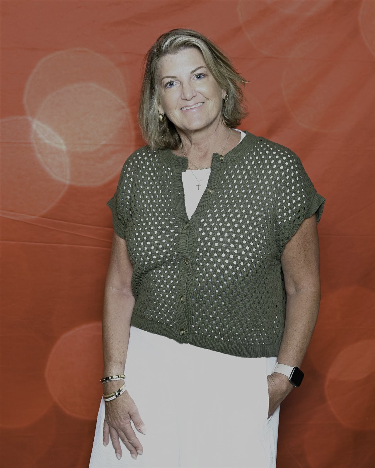 Marin wearing cream color dress and green sweater.
