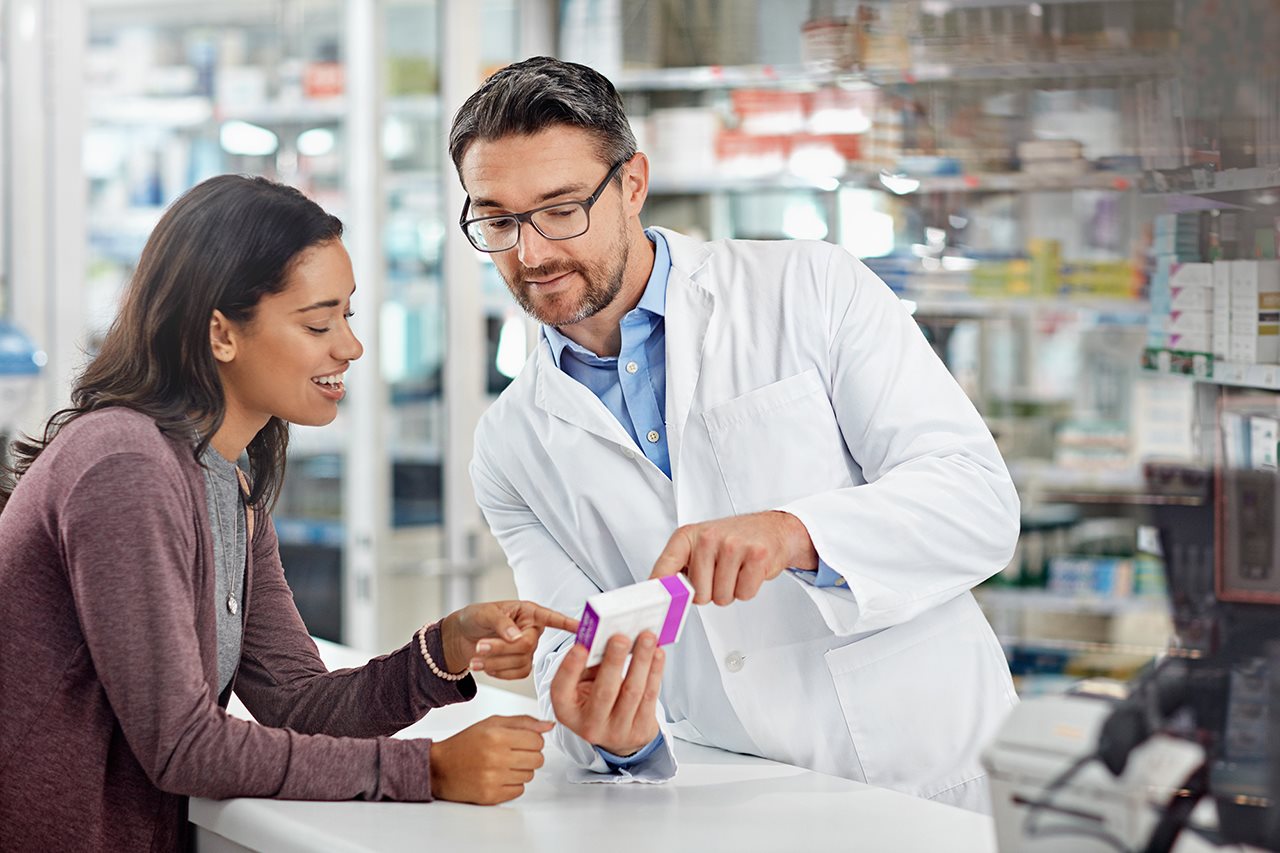 Woman in a drug store talking with a pharmacist