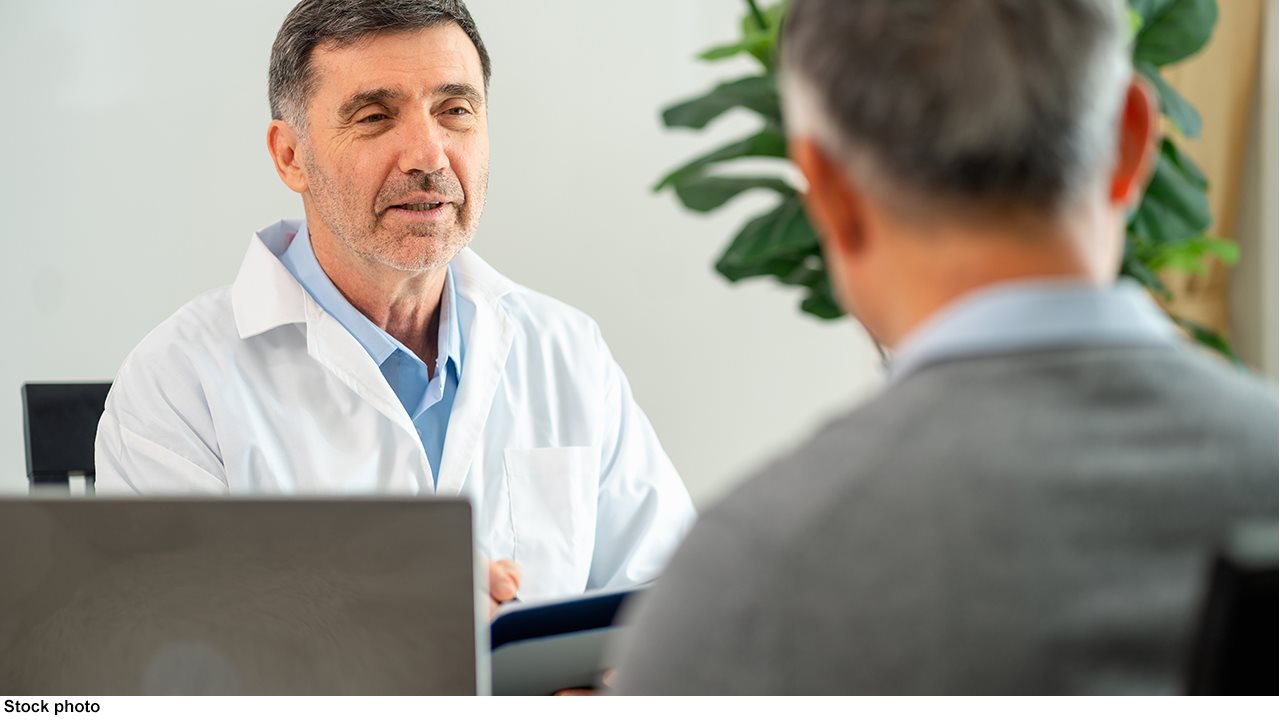 Doctor talking with patient in his office.