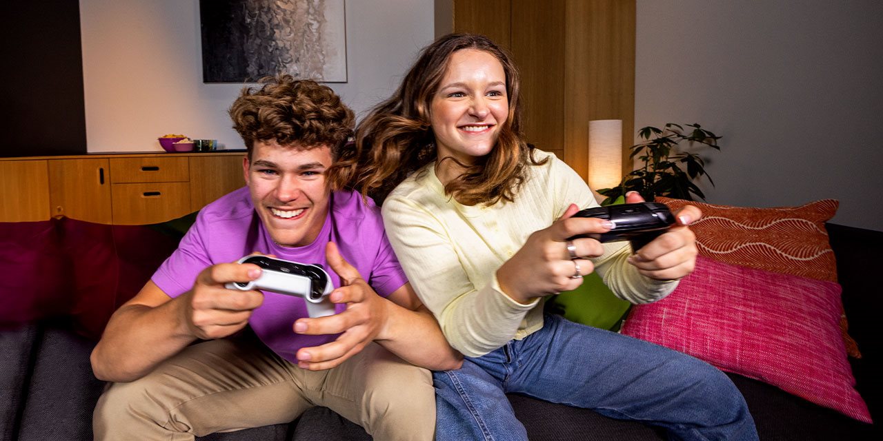 Madre e hijo jugando videojuegos usando la conexi&oacute;n Wi-Fi de T-Mobile en casa de un familiar.