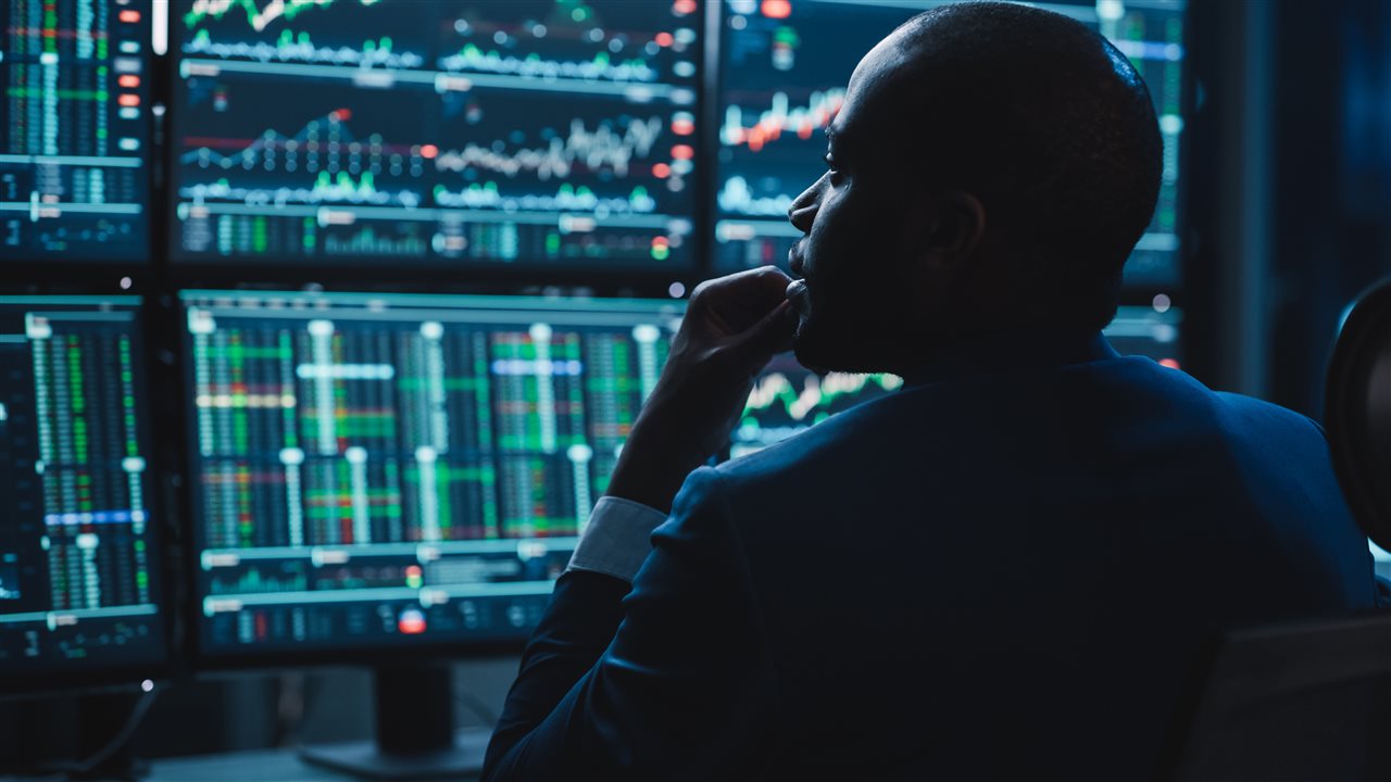 IT professional looking at patterns on multiple computer screens. Cognizant says AI-driven defense systems now detect and respond in milliseconds