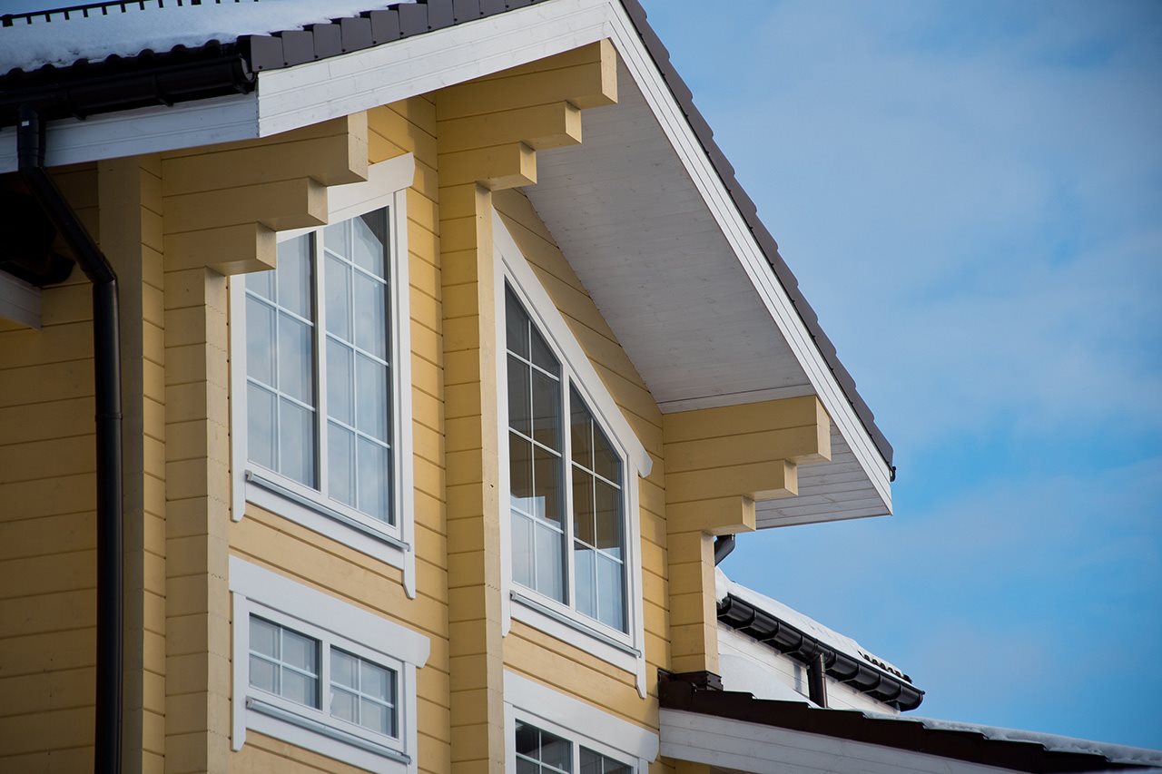Yellow facade of a house with two windows.