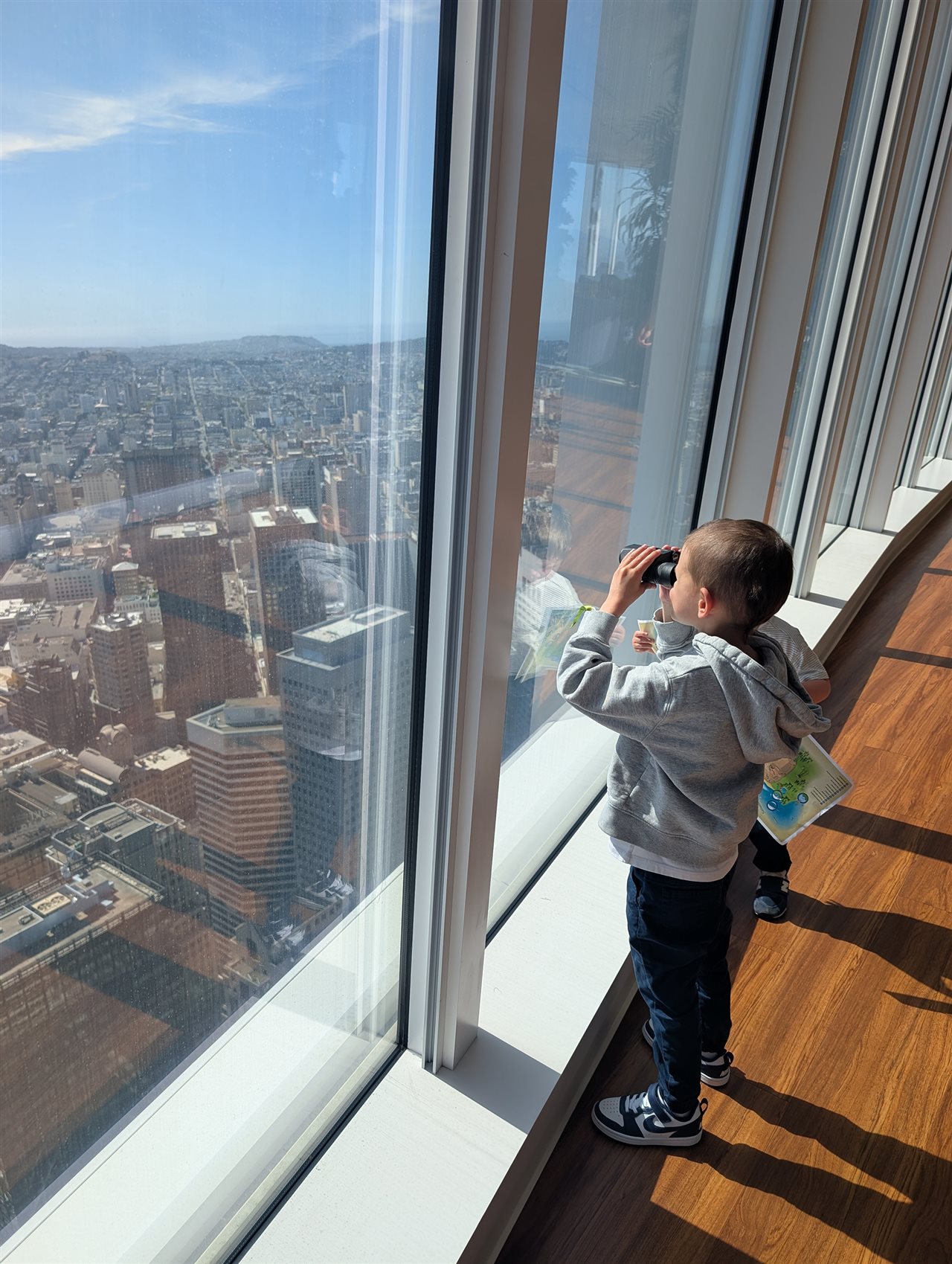 Make-A-Wish kid, Sam, and family at Salesforce's San Francisco office enjoy the view of the city's famous landmarks.