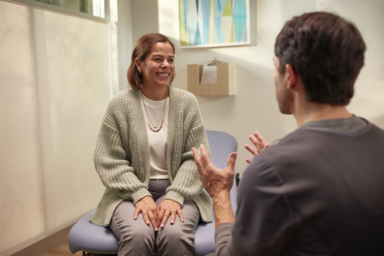 Doctor talking with middle-aged woman. One Medical's providers focus on preventive care and chronic condition management.