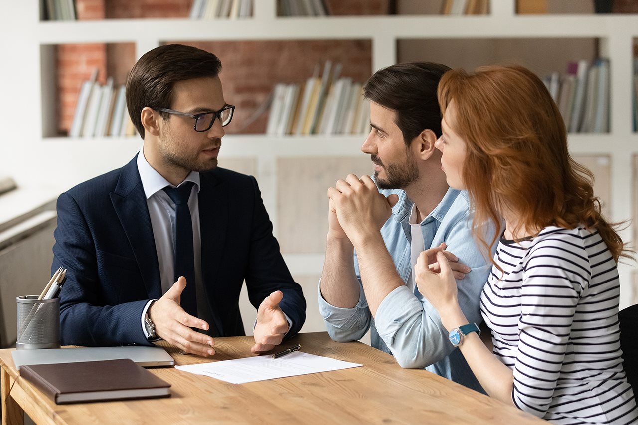 couple talking with agent in his office