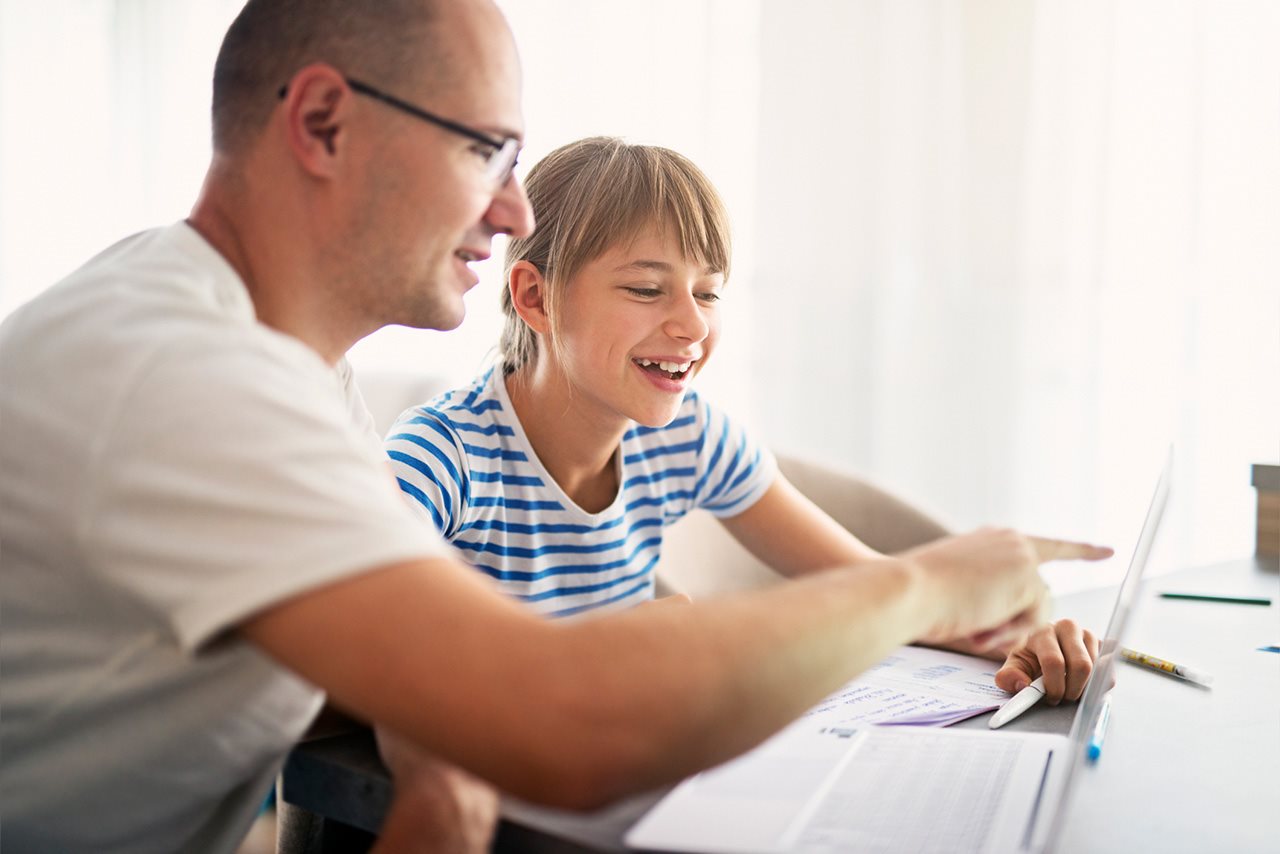 A father helps his daughter with her homework.