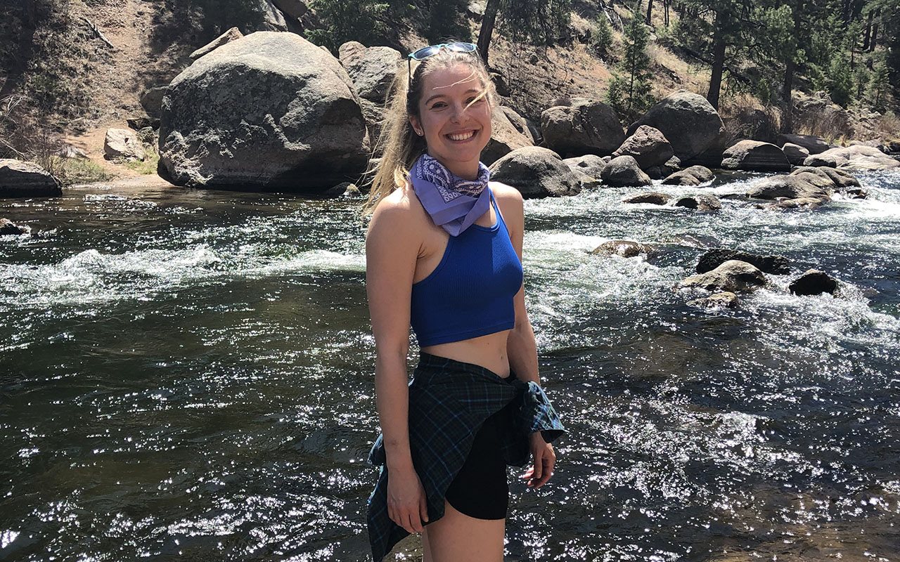 Caroline in summer clothes standing in a water brook.