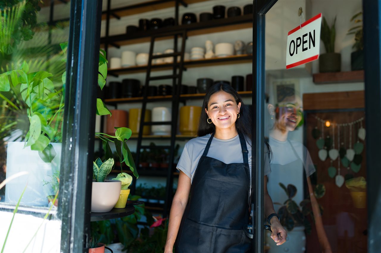 Mujer en la entrada de su tienda de plantas. Unidos US aborda el alojamiento, la estabilidad laboral, la creaci&oacute;n de negocios y apoya a las familias latinas.