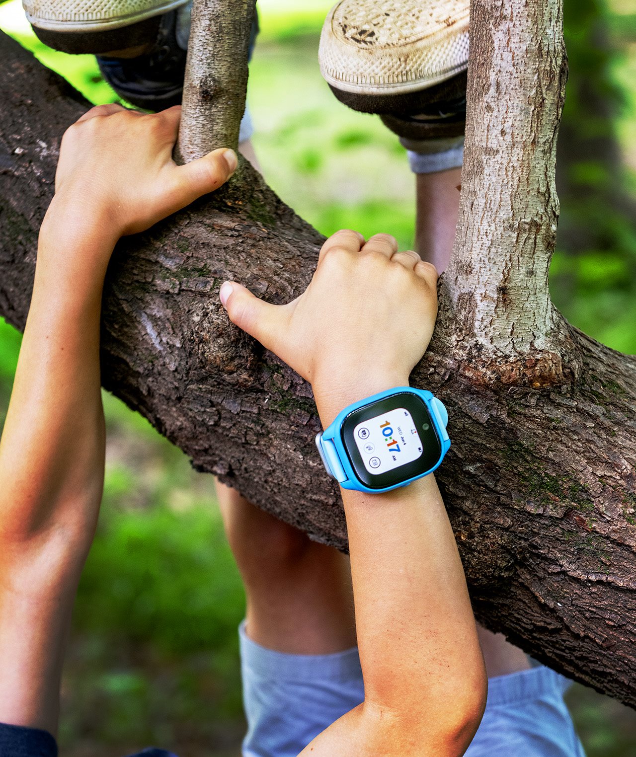 Child wearing a phone/watch while climbing a tree