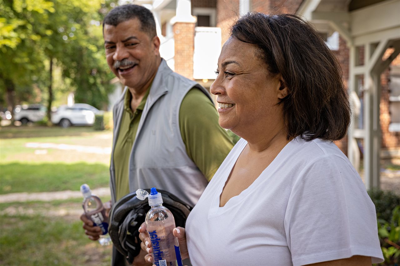 A older couple taking a walk in their neighborhood.