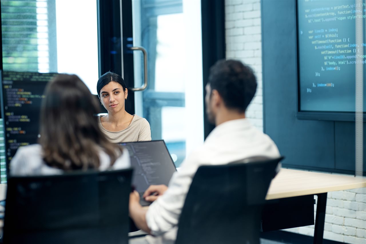 Group of IT people writing computer code