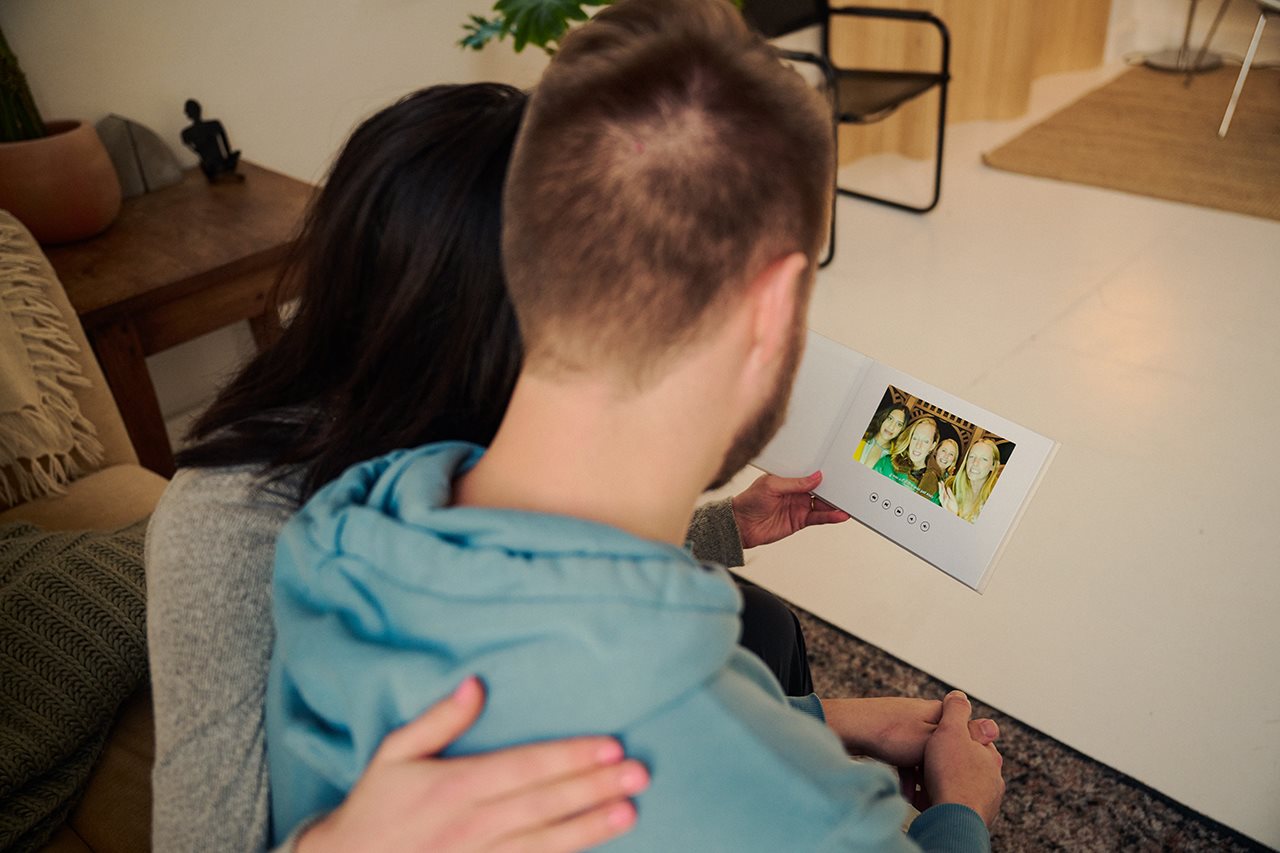 Couple looking at their Voast wedding booth video book