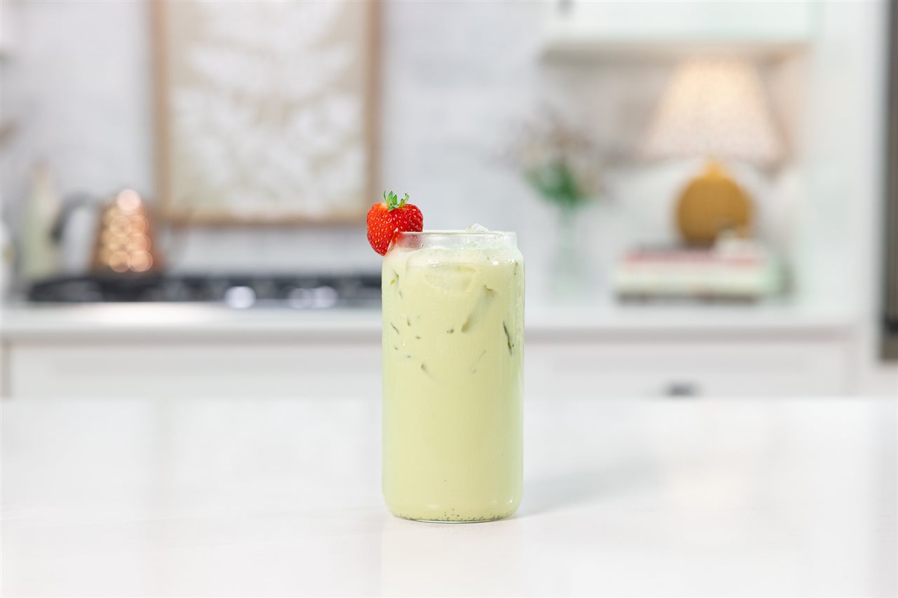 A glass of Strawberry Matcha Milk, an earthy matcha and strawberry flavor with Organic Valley<sup><sup><sup><sup><sup><sup><sup><sup><sup>&reg;</sup></sup></sup></sup></sup></sup></sup></sup></sup> Lactose-Free milk, on a counter in the kitchen.