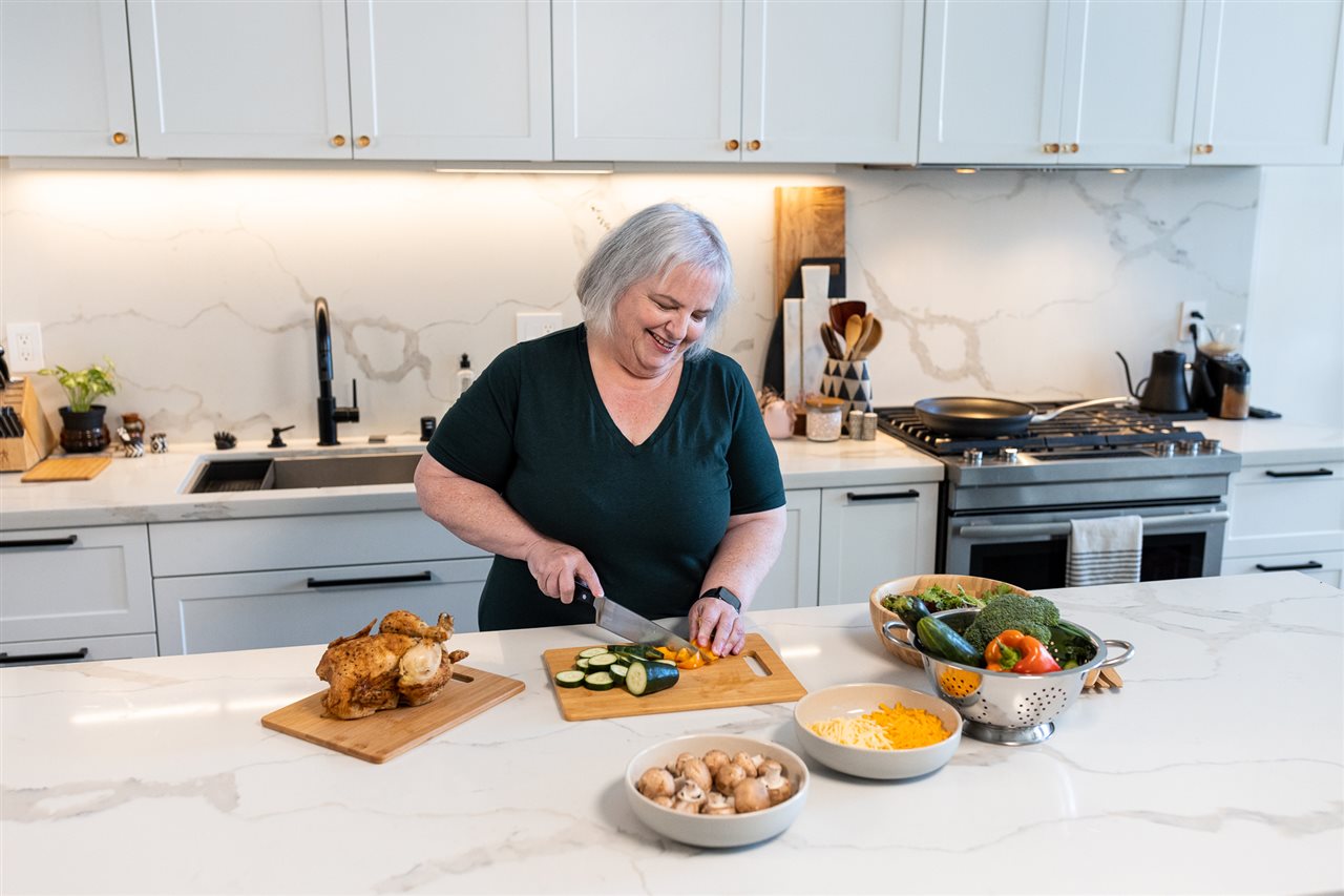 Woman chops vegetables. Virta Vitals report says 61% of Americans would rather improve health through behavior change..