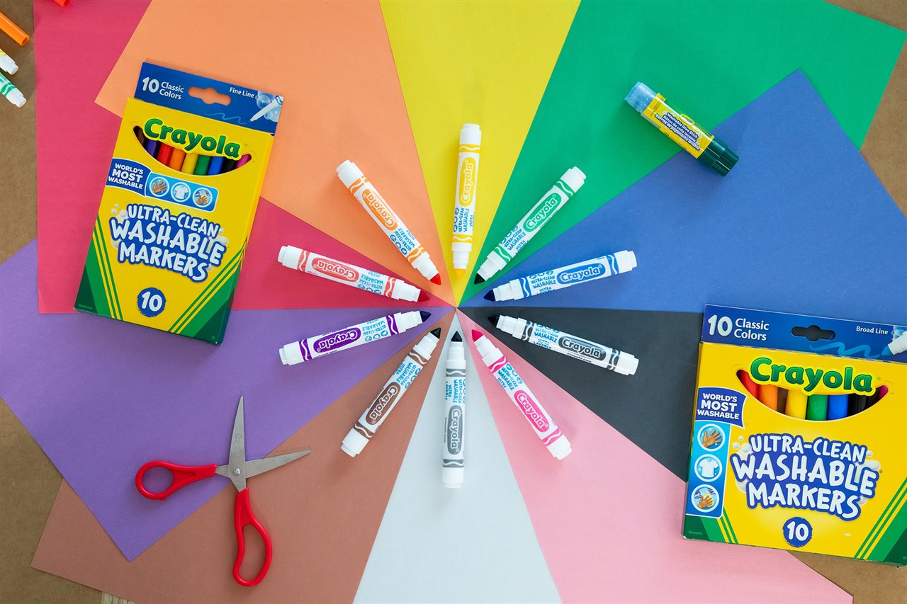 Marcadores Crayola Ultra Clean de punta gruesa y fina sobre un fondo de papel multicolor.