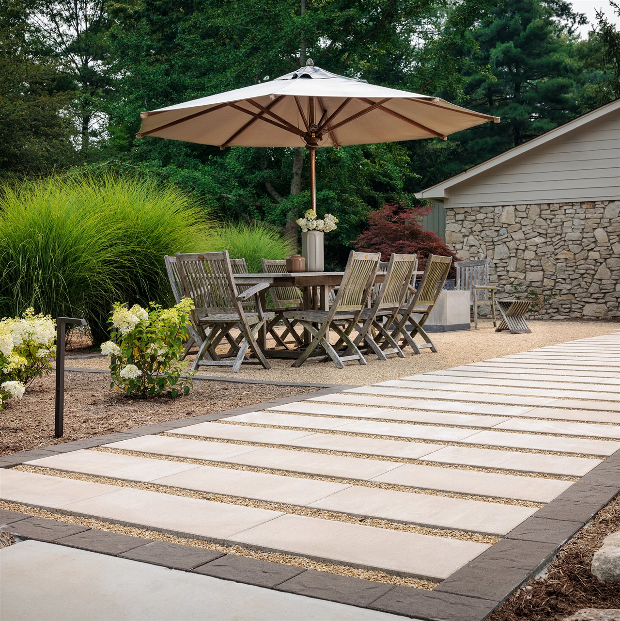 Belgard dimentional slab patio with outdoor dinning area and beautiful plantings.