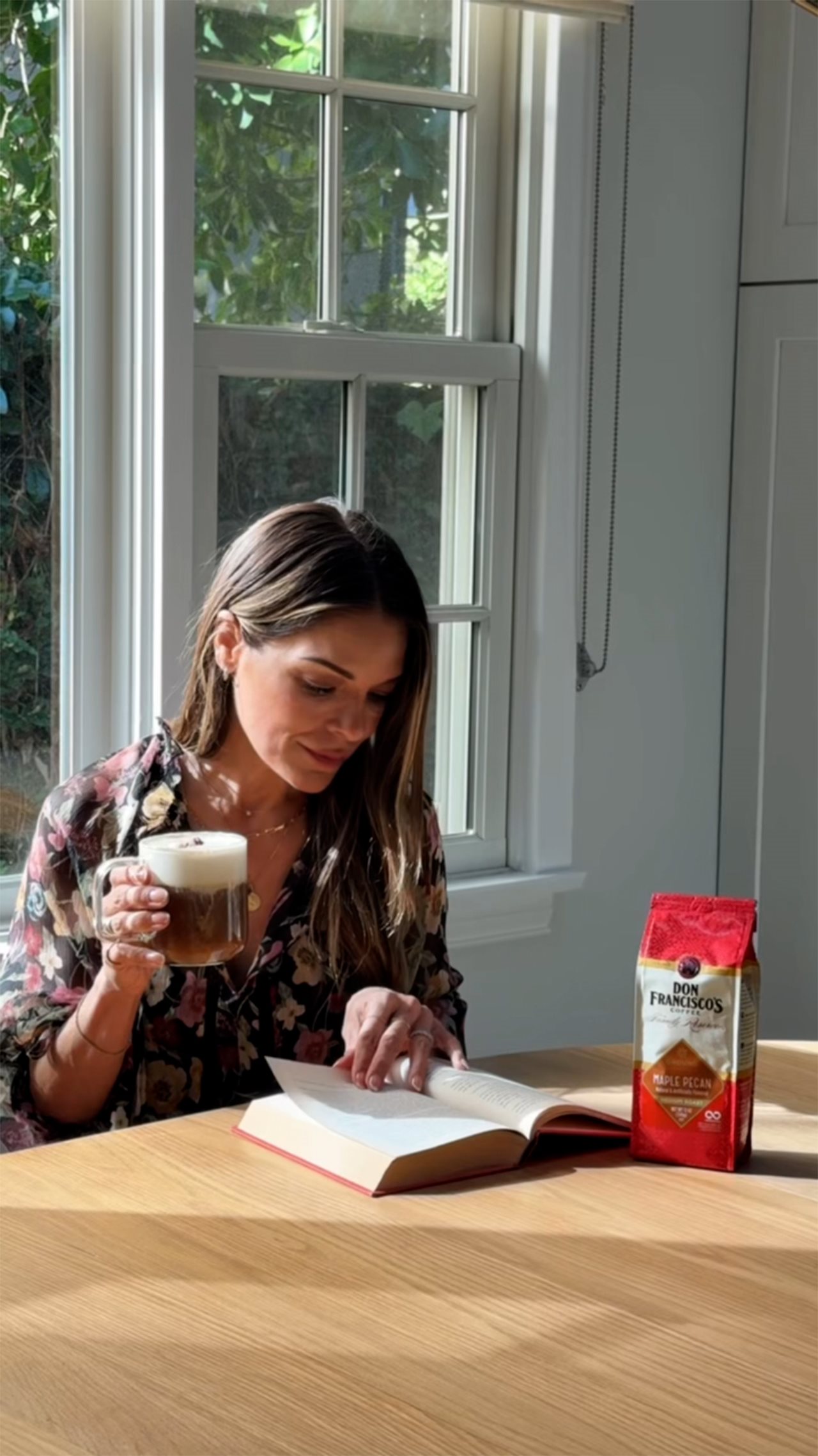 Sabrina Soto sipping Don Francisco's Coffee while reading a book.
