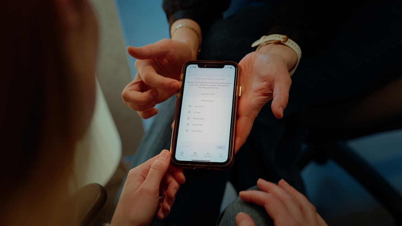 Doctor and woman using mobile app. Prescriby Health has a service and digital app that helps patients reduce medication.