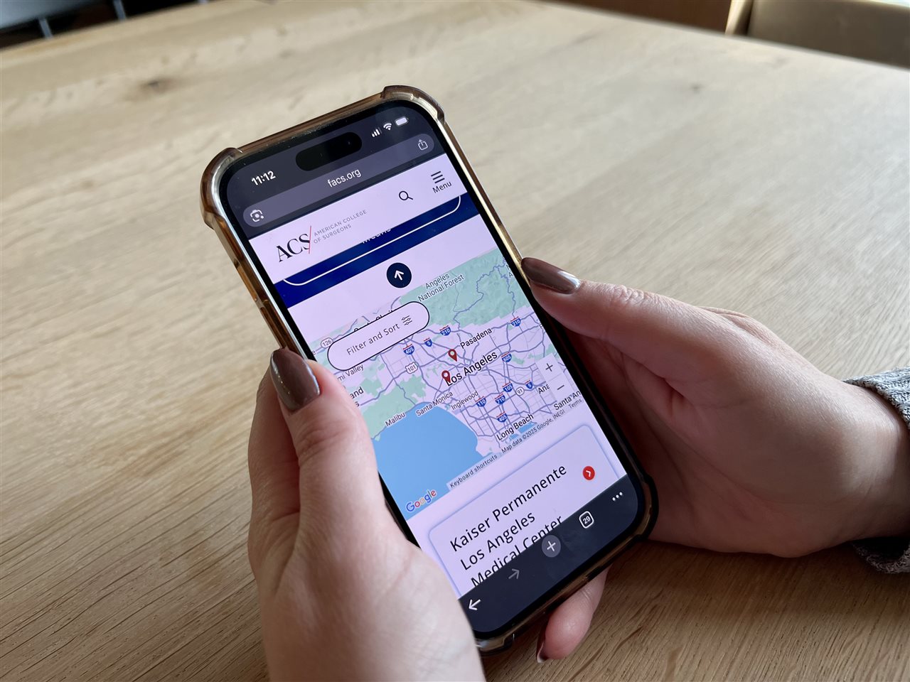 Person using the ACS app on their phone to find a hopital.