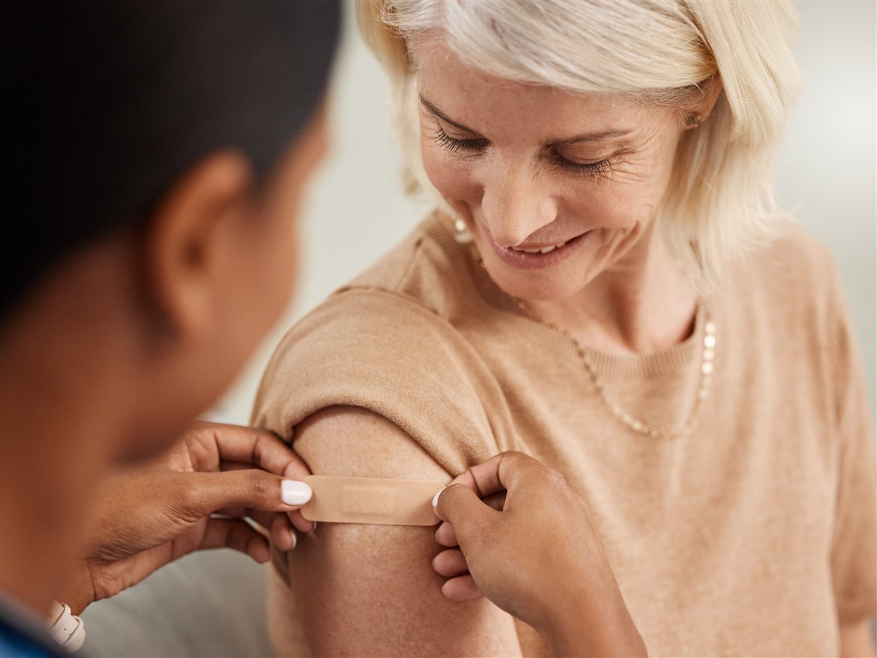 Senior woman getting her flu shot at a clinic.