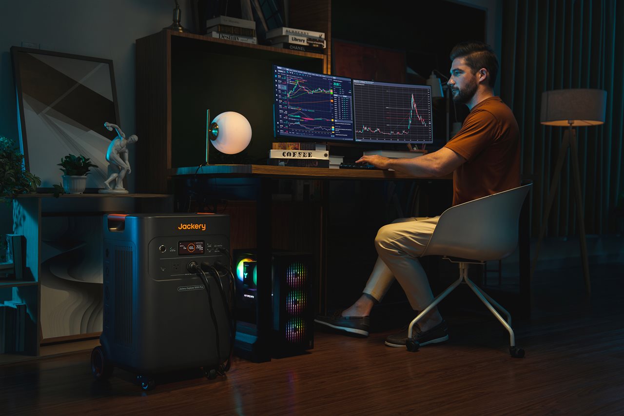 Man using computer powered by Jackery back-up home power.