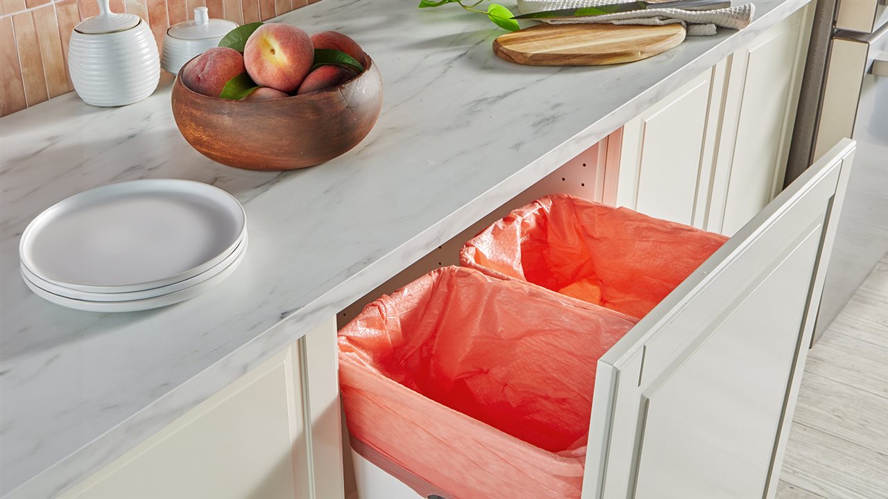 Trash bags in a kitcken trash bins. Hefty<sup><sup><sup>®</sup></sup></sup> Color Series trash bags with the Fabuloso<sup><sup><sup>®</sup></sup></sup> Peach fragrance helps your kitchen stay clean.