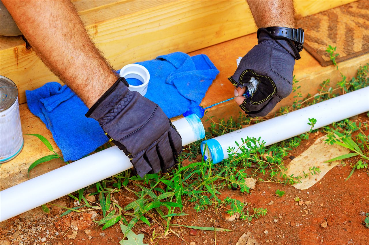 Worker connects two pieces of vinyl pipe. Learn more about PVC pipe and other vinyl products at www.vinylinfo.org