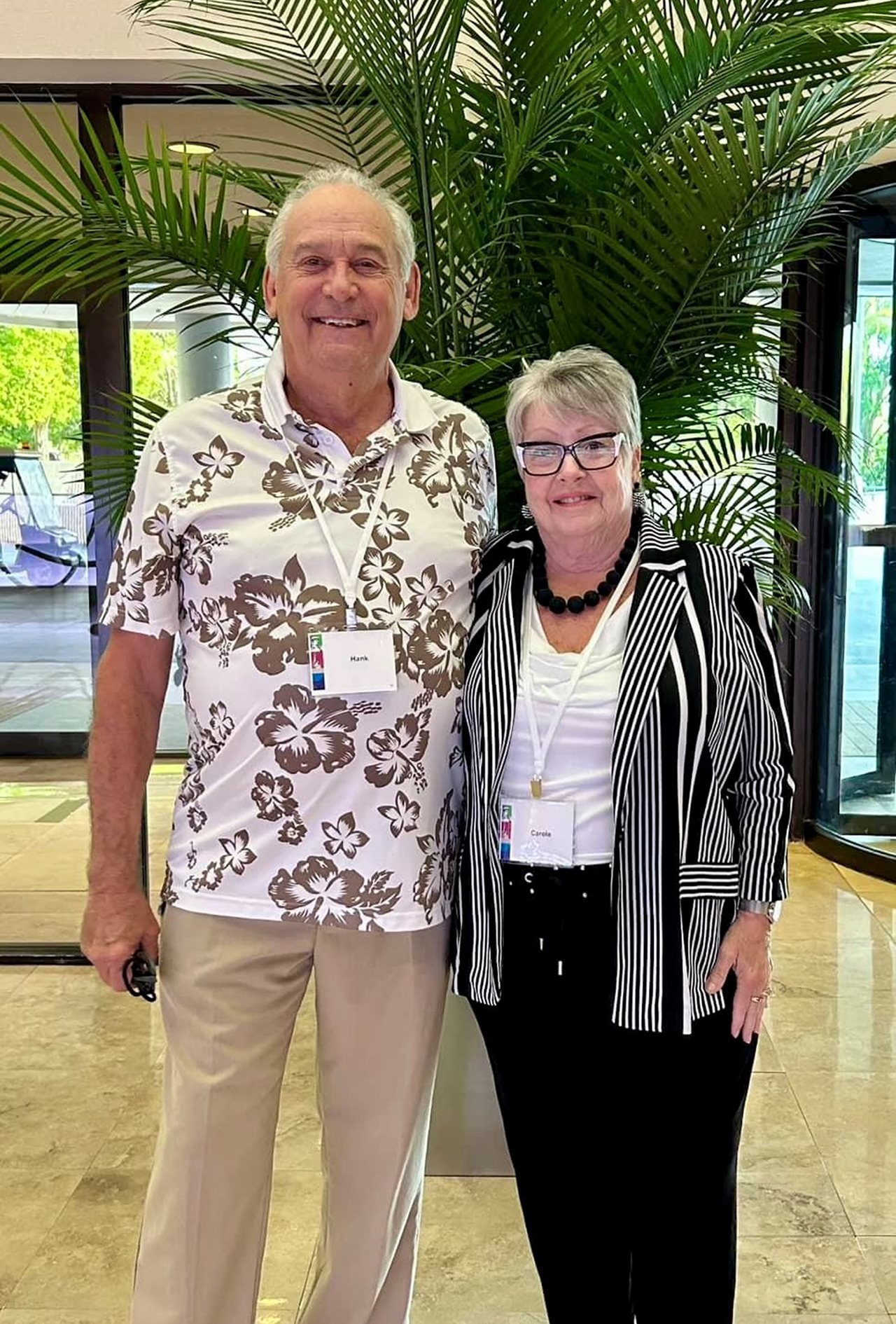 Smiling Carole and Hank at a conference in a tropical location.