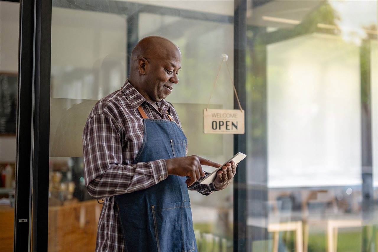 Business owner uses cell phone. Synchrony helps businesses with digital tools, training and financing infrastructure.