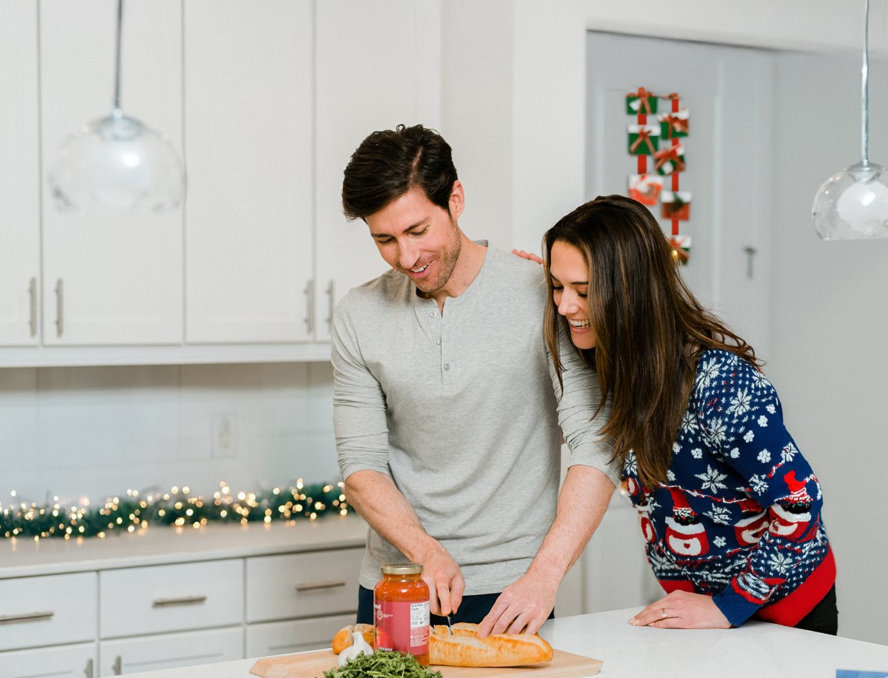 Young couple preparing a platter of snacks for holiday guests.