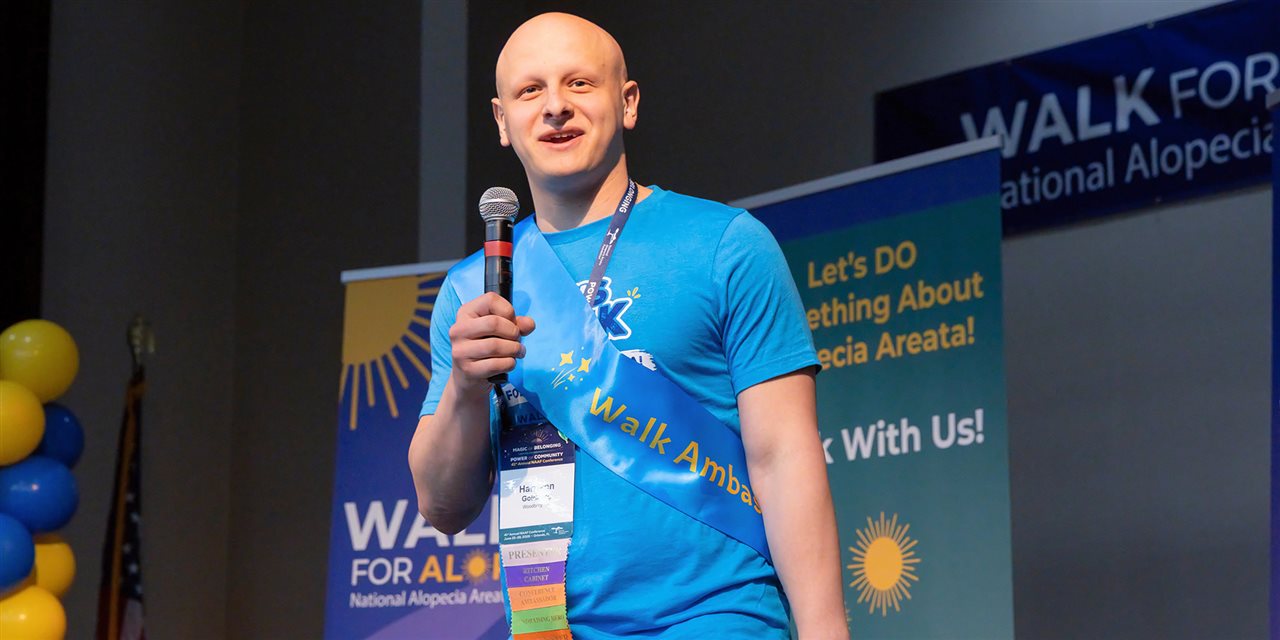 Harrison, a National Walk For Alopecia Ambassador, speaking with a microphone.