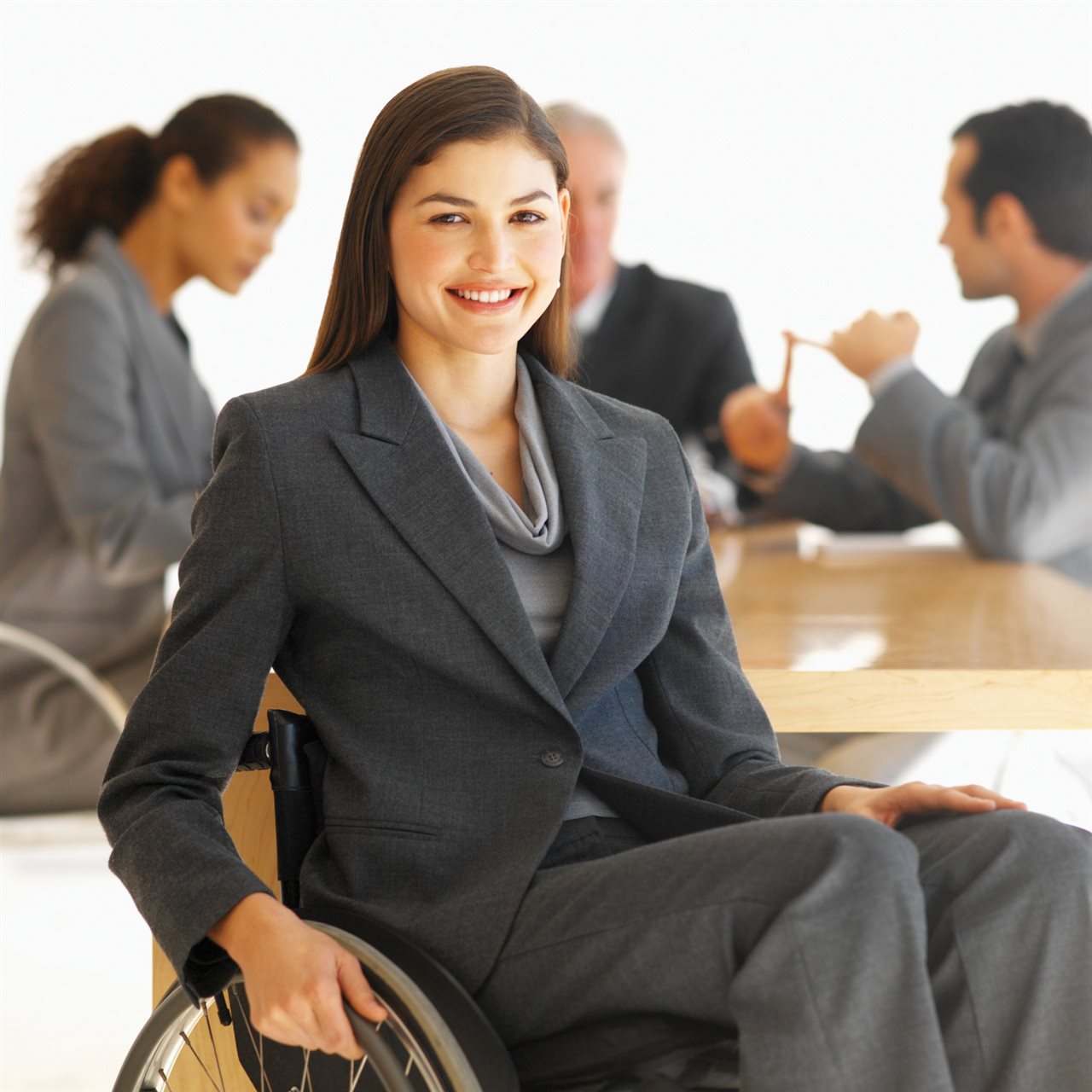 Woman living with a disability wearing a buisness suit and sitting in a wheel chair.