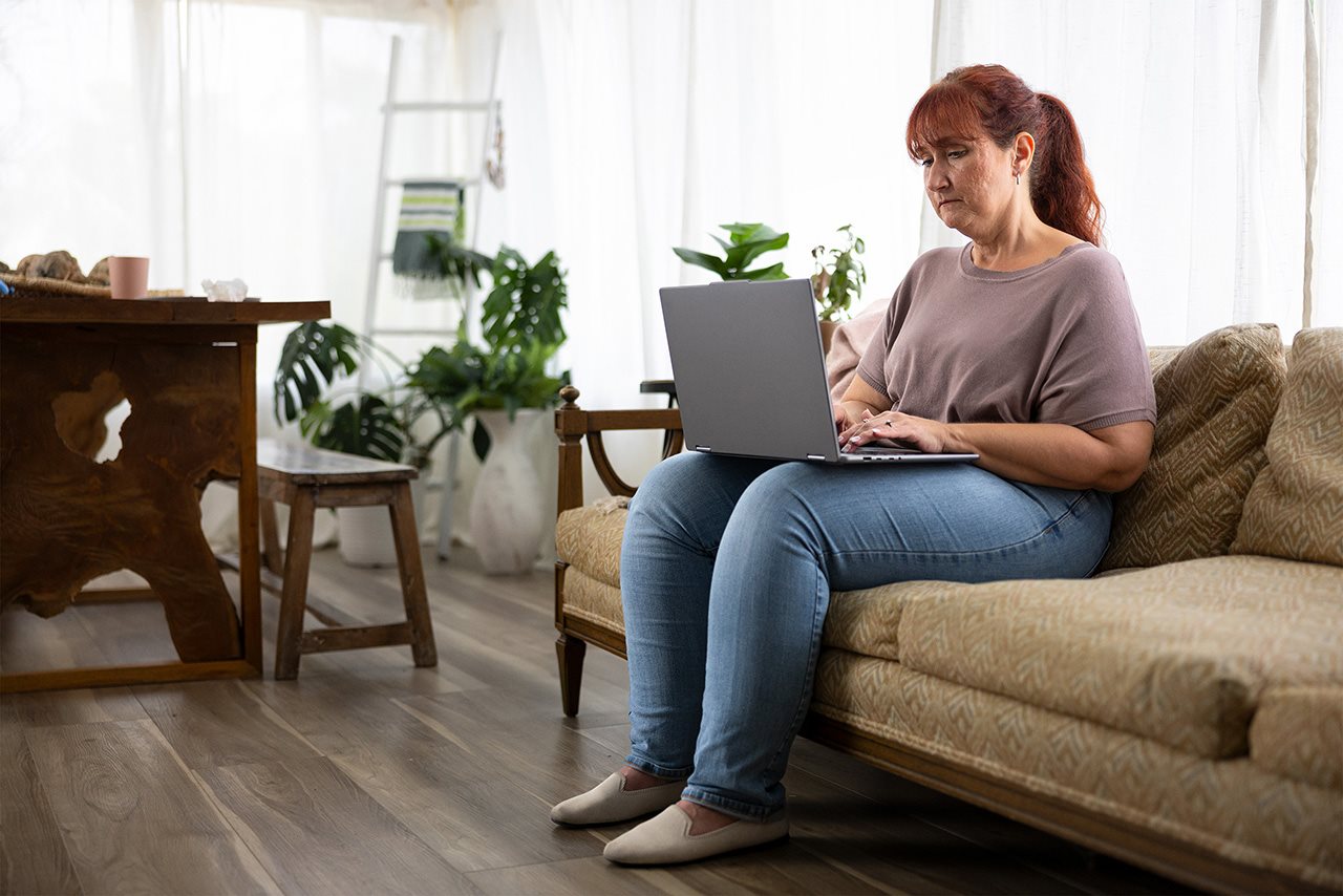 Rosetta using a laptop while sitting on a couch in her home