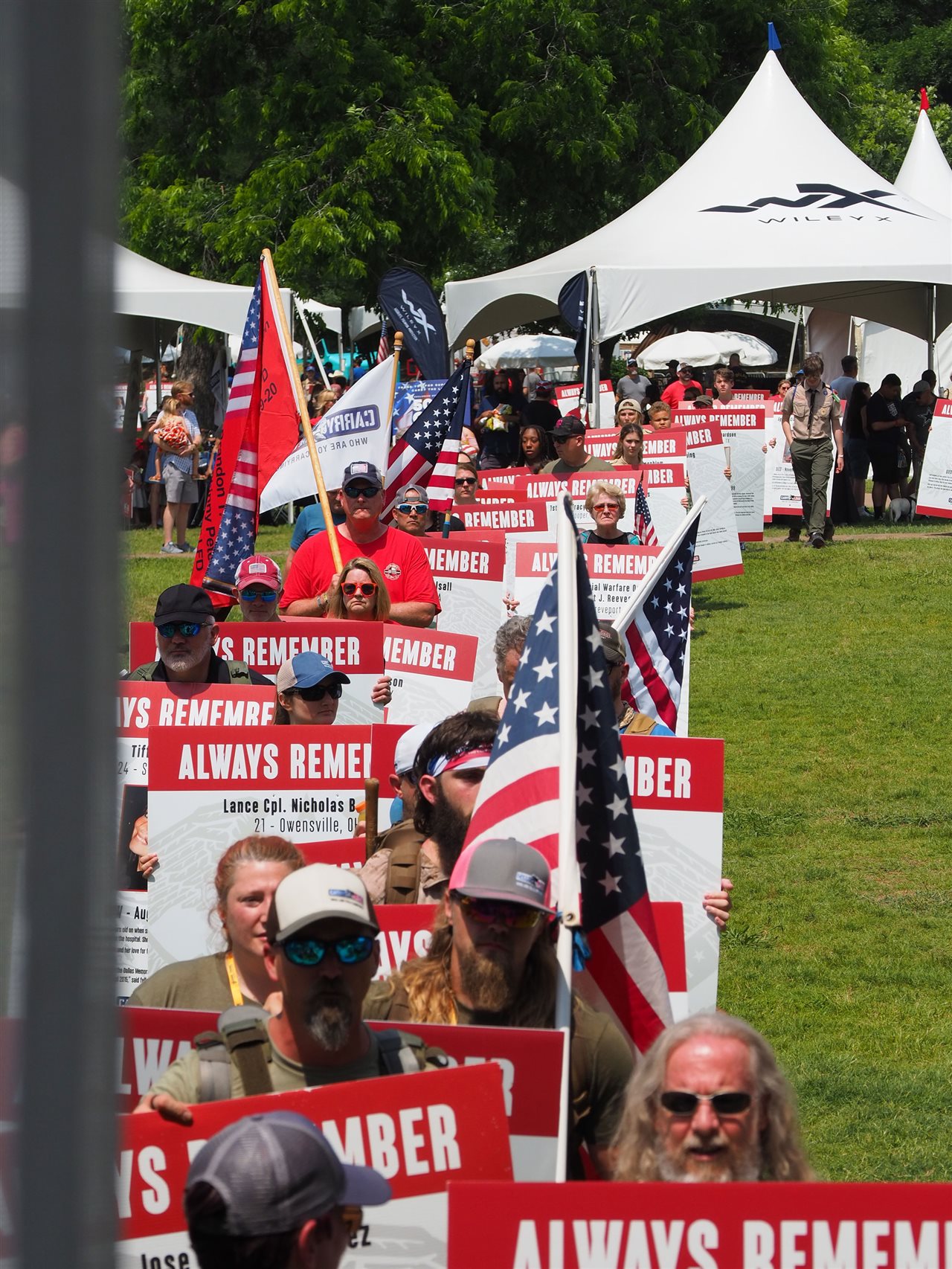 Participates with flags and signs in a Carry The Load community event.