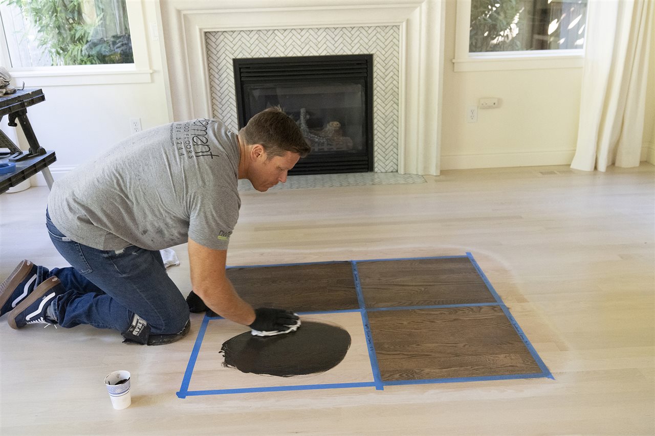 Man staining a hardwood floor. A Bona Certified Craftsman ensures your floor will be beautifully refinished.