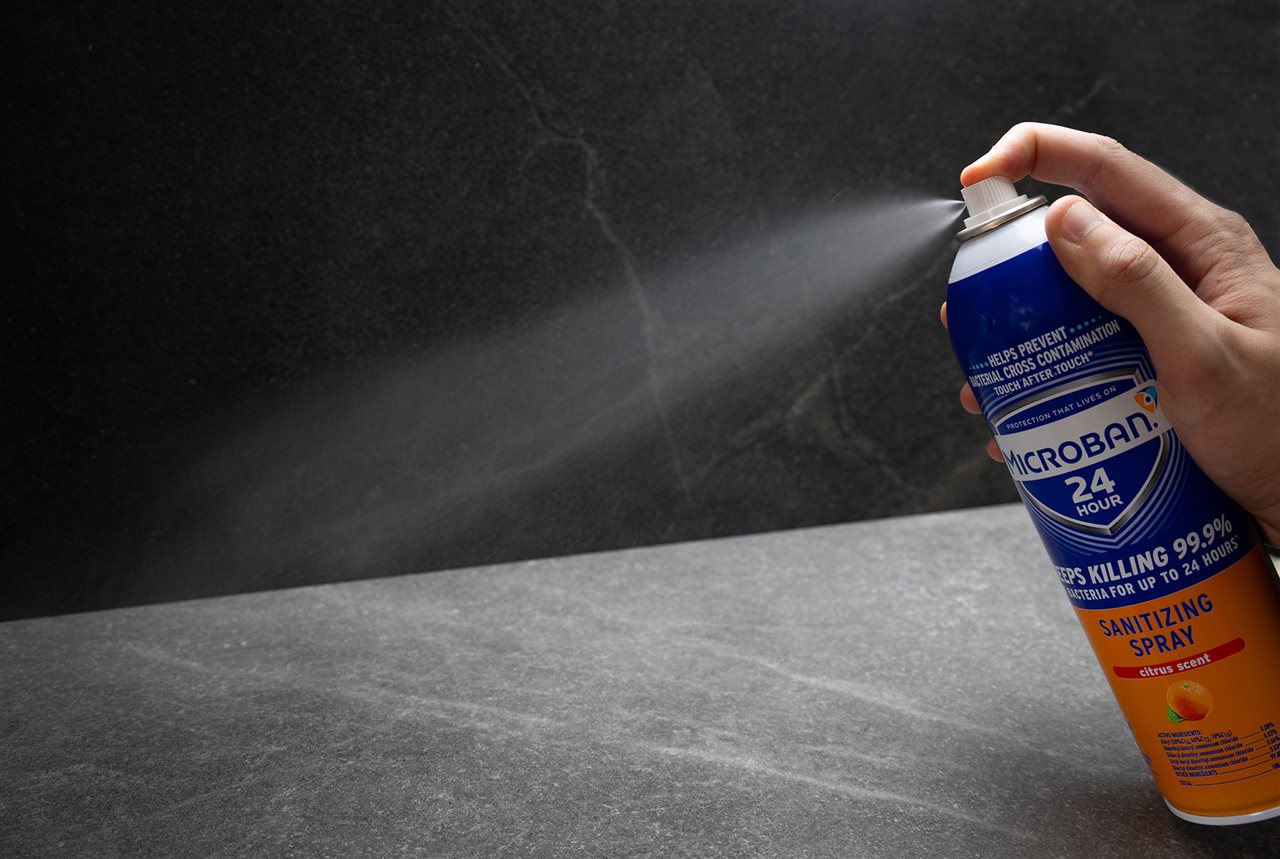 Person spraying a counter top with