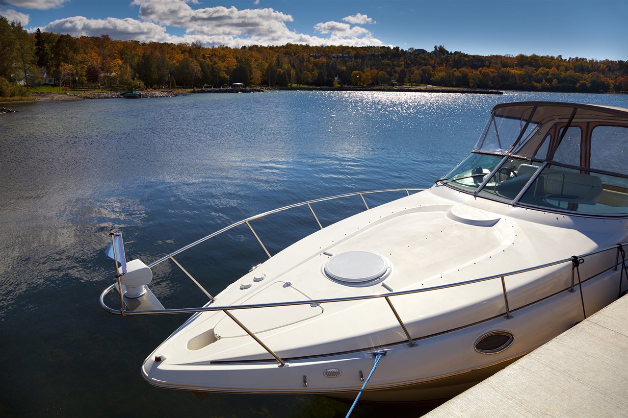 Boat by a dock and Fall colored shoreline.