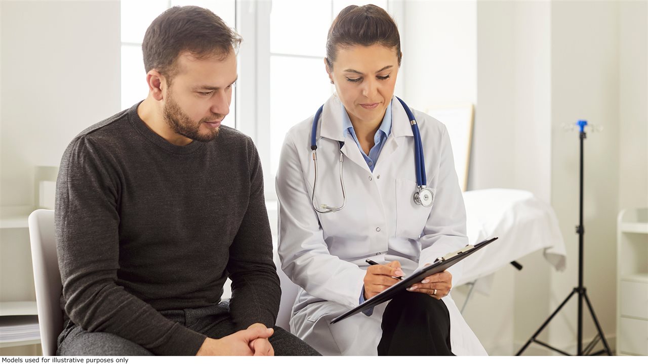 Man talking with female doctor about treatment.