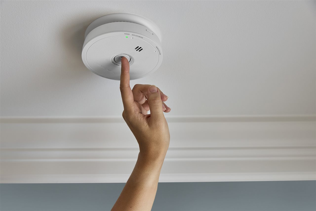Person testing the First Alert smoke, CO and combination alarm.